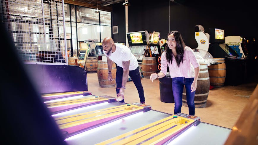 Two people playing Skee-Ball in at Cidercade in Dallas