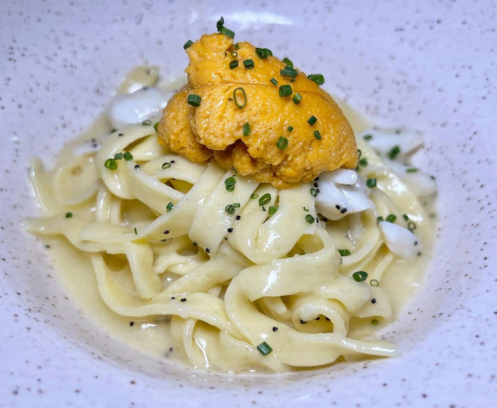 A pile of pasta topped with uni 