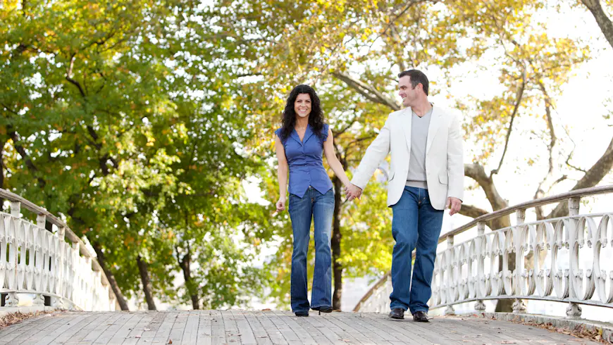 A couple walking on a historic bridge in Central Park, New York City, New York, USA
