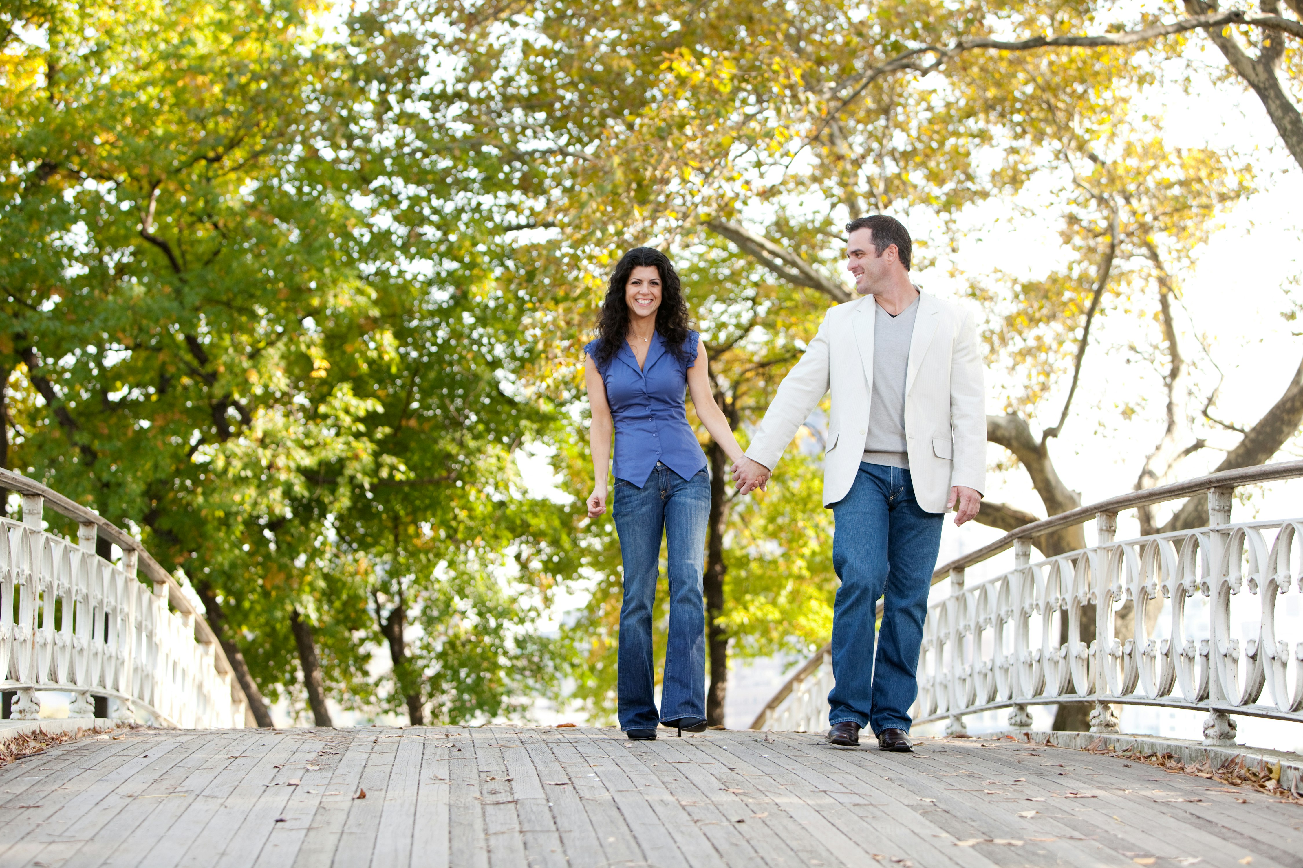 A couple walking on a historic bridge in Central Park, New York City, New York, USA