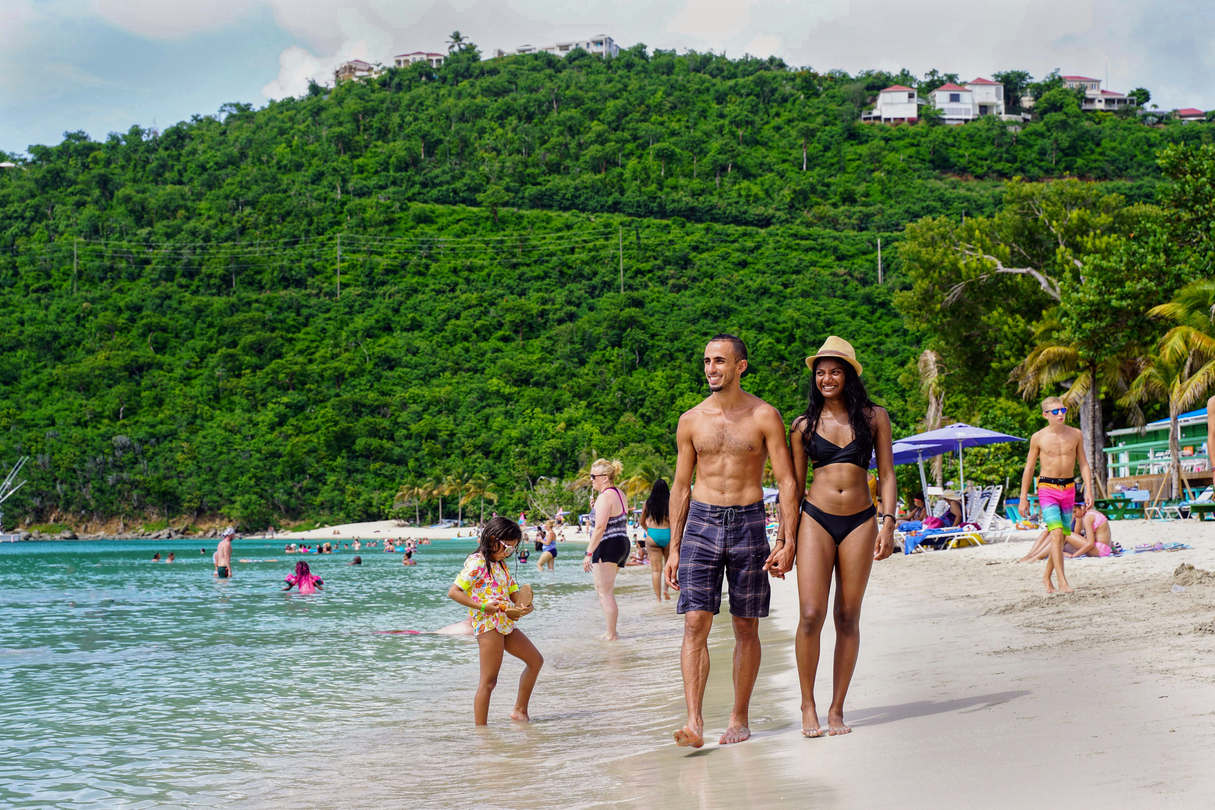Magen's Bay, St Thomas United States Virgin Islands - August 18 2019: Happy, mixed race, South Asian couple walking beside the water at Magens Bay Beach in St. Thomas United States Virgin Islands.; Shutterstock ID 1972015679; your: Brian Healy; gl: 65050; netsuite: Lonely Planet Online Editorial; full: Best things to do in St Thomas