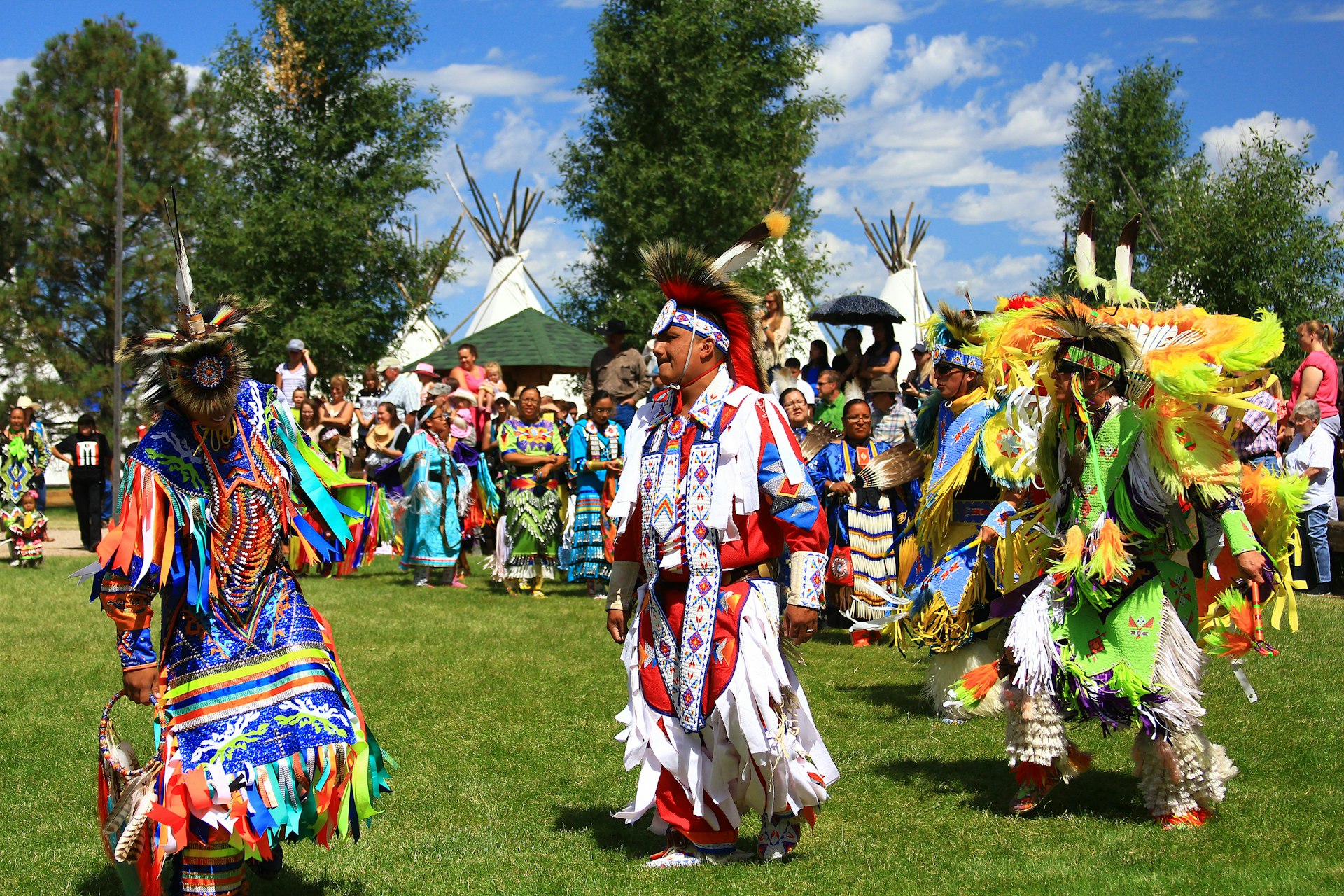 Native American performers in costume dance at a pow-wow.