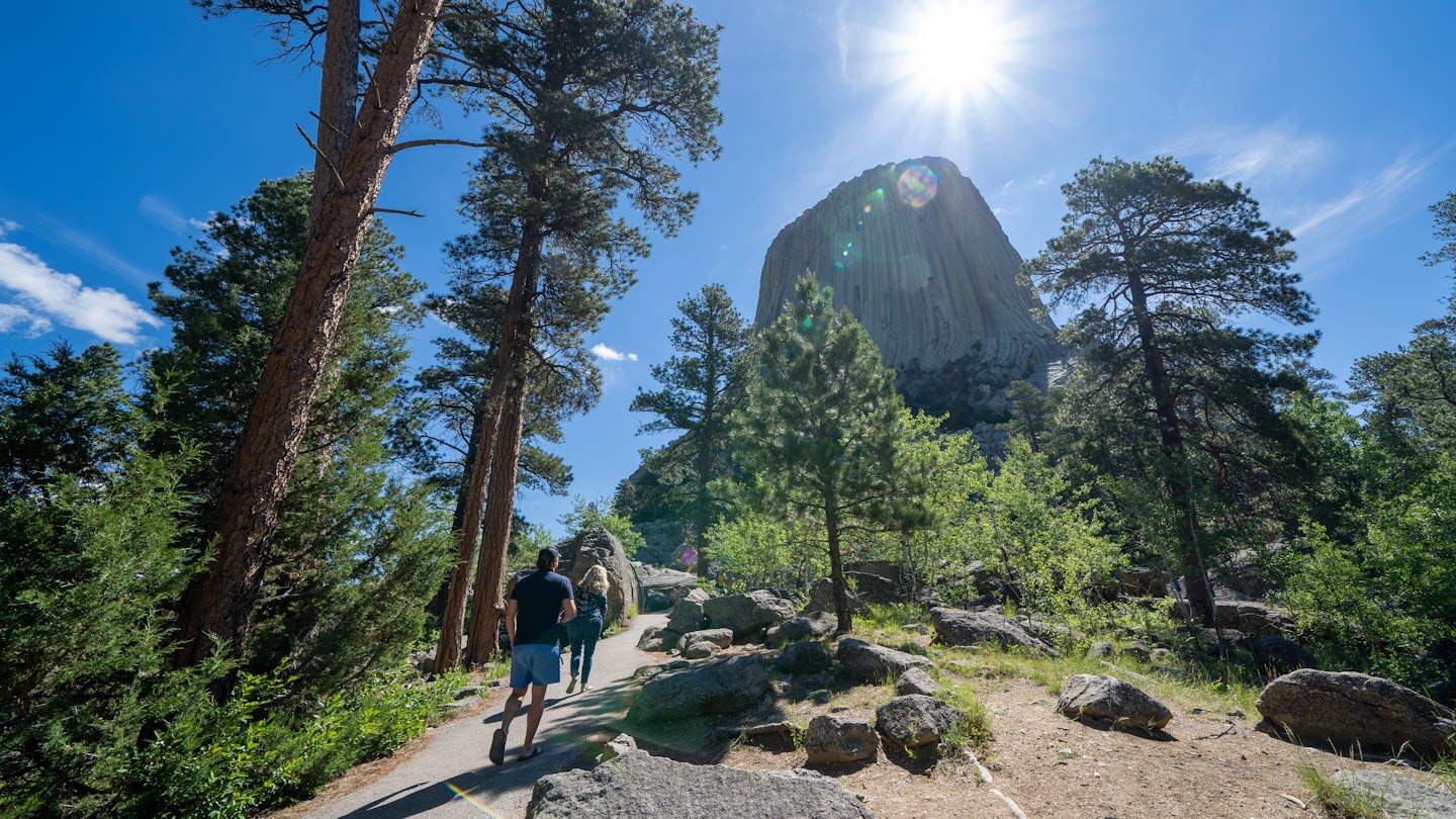 Hikers walk towards Devils Tower National Monument in Wyoming