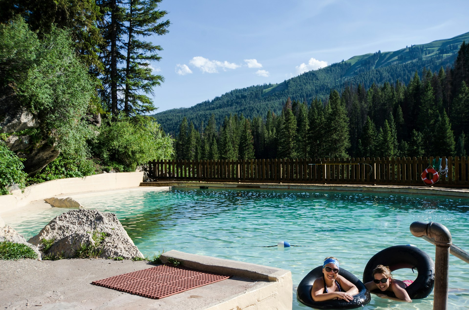 Two women in black rubber rings in an artificial pool fed by hot springs in Wyoming
