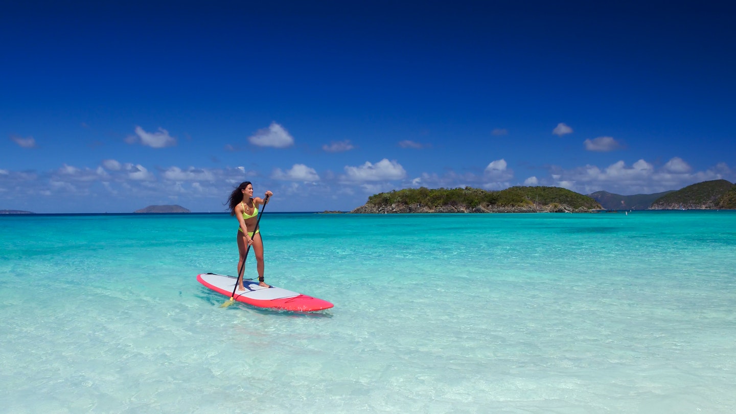 young attractive multi-ethnic woman on paddle board at cinnamon bay, United States Virgin Islands