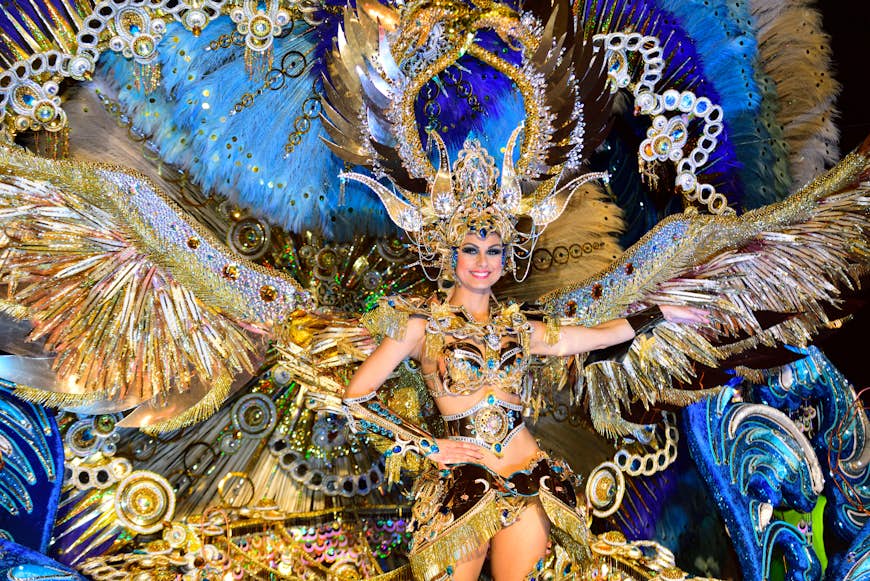 A woman in elaborate gold and blue dress dances at Carnaval in Santa Cruz de Tenerife