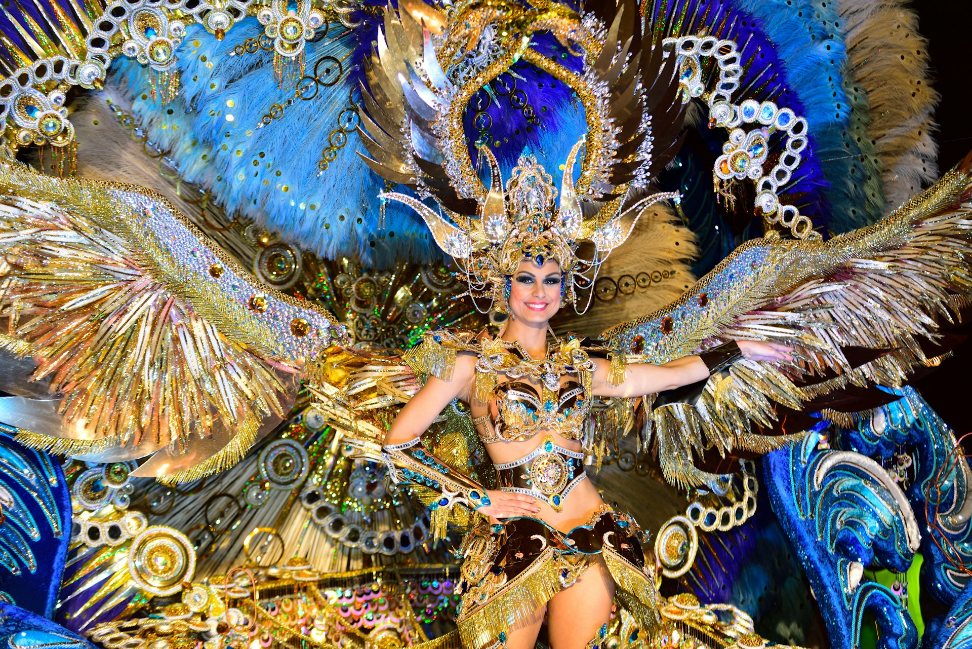 A woman in elaborate gold and blue dress dances at Carnaval in Santa Cruz de Tenerife