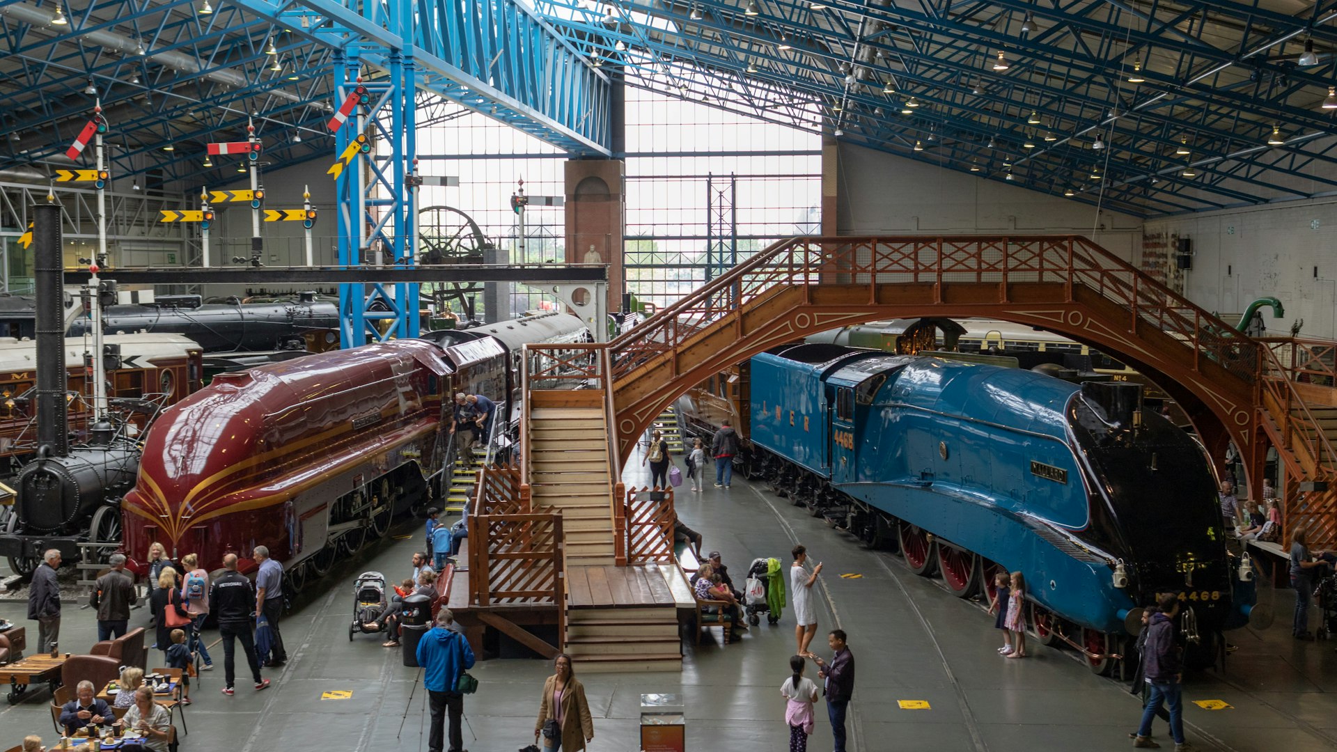 Tourists walk around a red and blue locomotive at the National Railway Museum