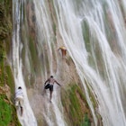 NOVEMBER 24, 2011: Young men climb the steep face of El Limón waterfall.