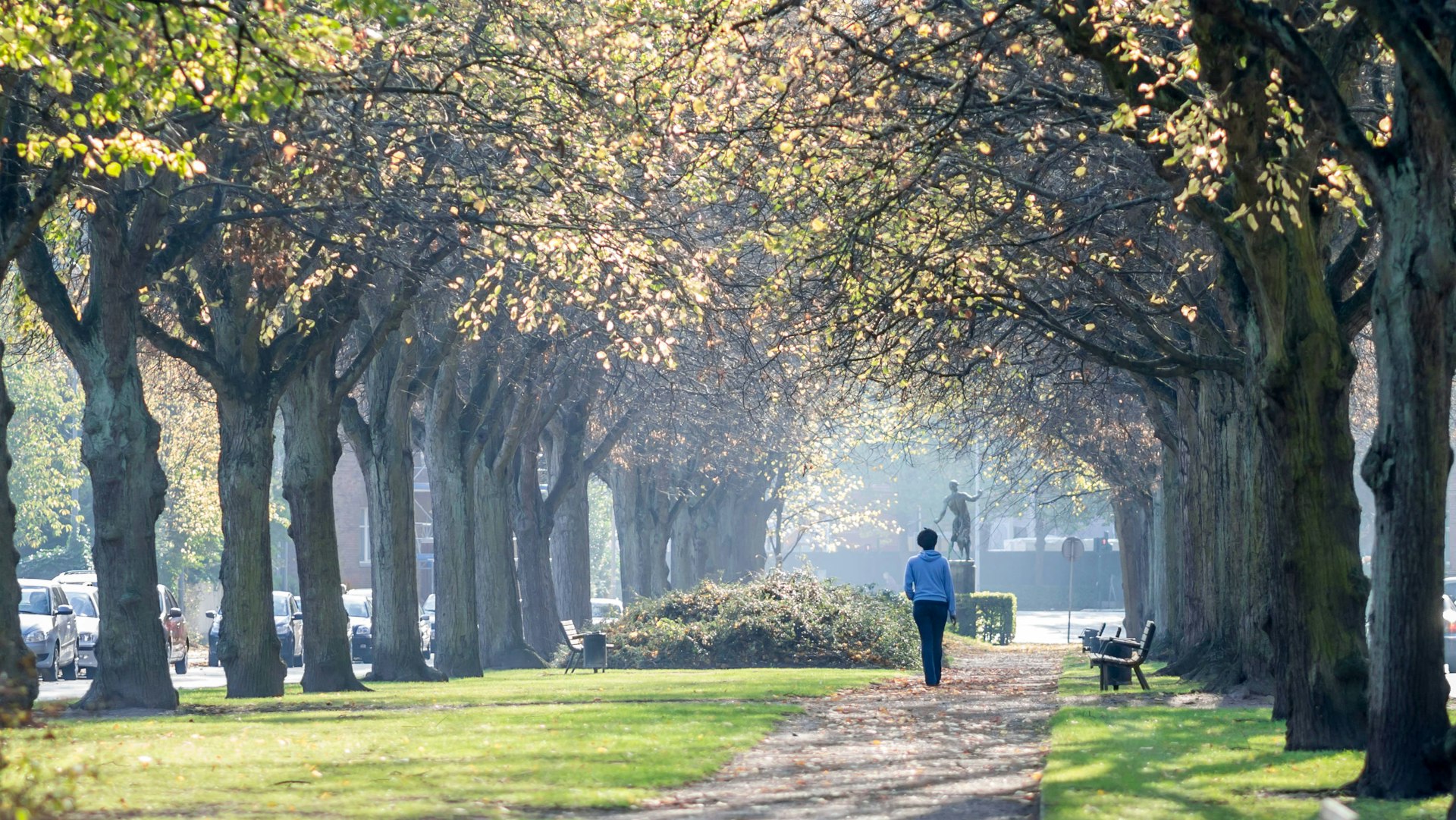 A woman walking alone in Frederiksberg Have garden, Copenhagen, Denmark