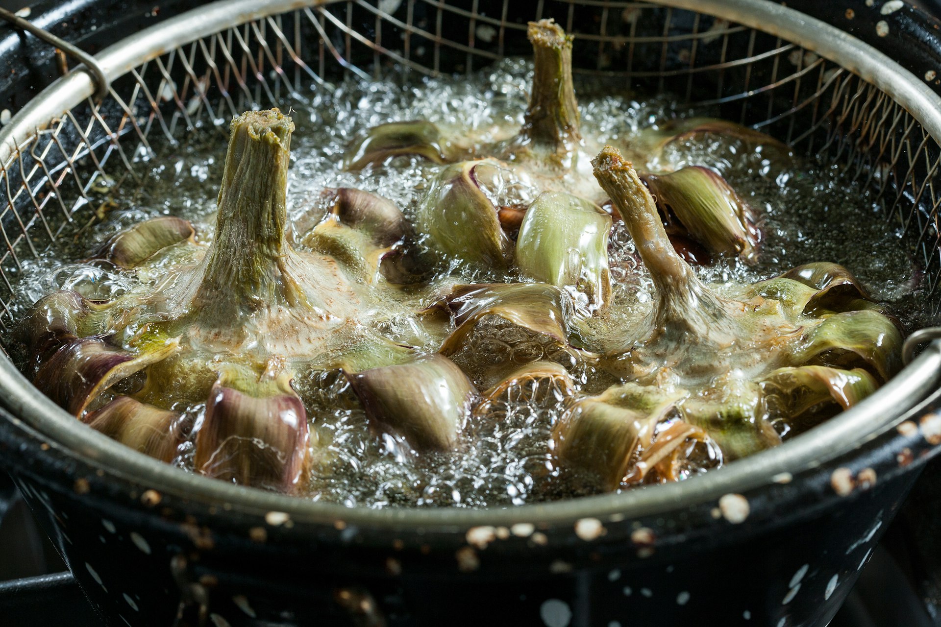 Close-up of frying artichokes in a pot of hot oil