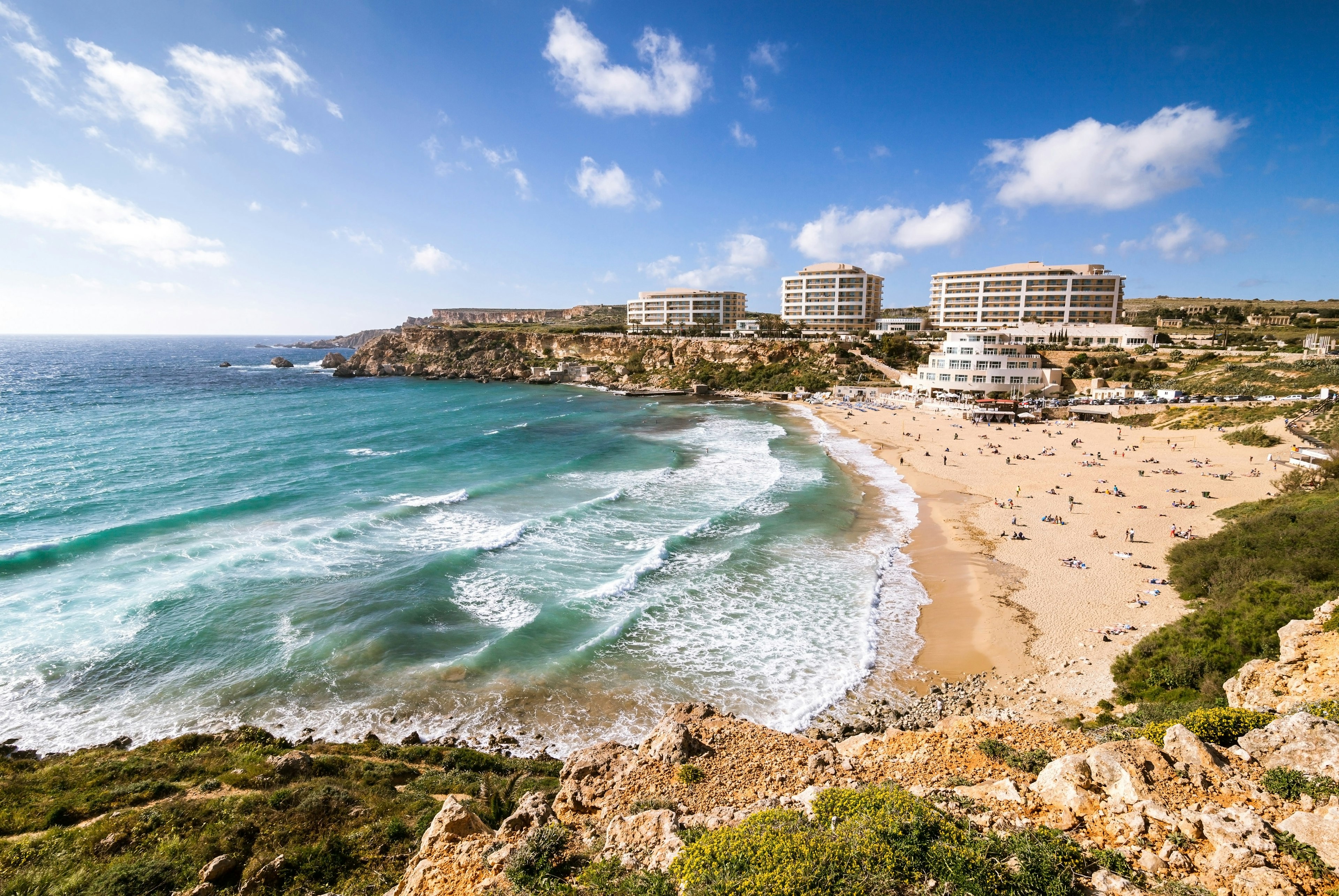 wide angle image of the beach with a hotel at Golden bay in Malta