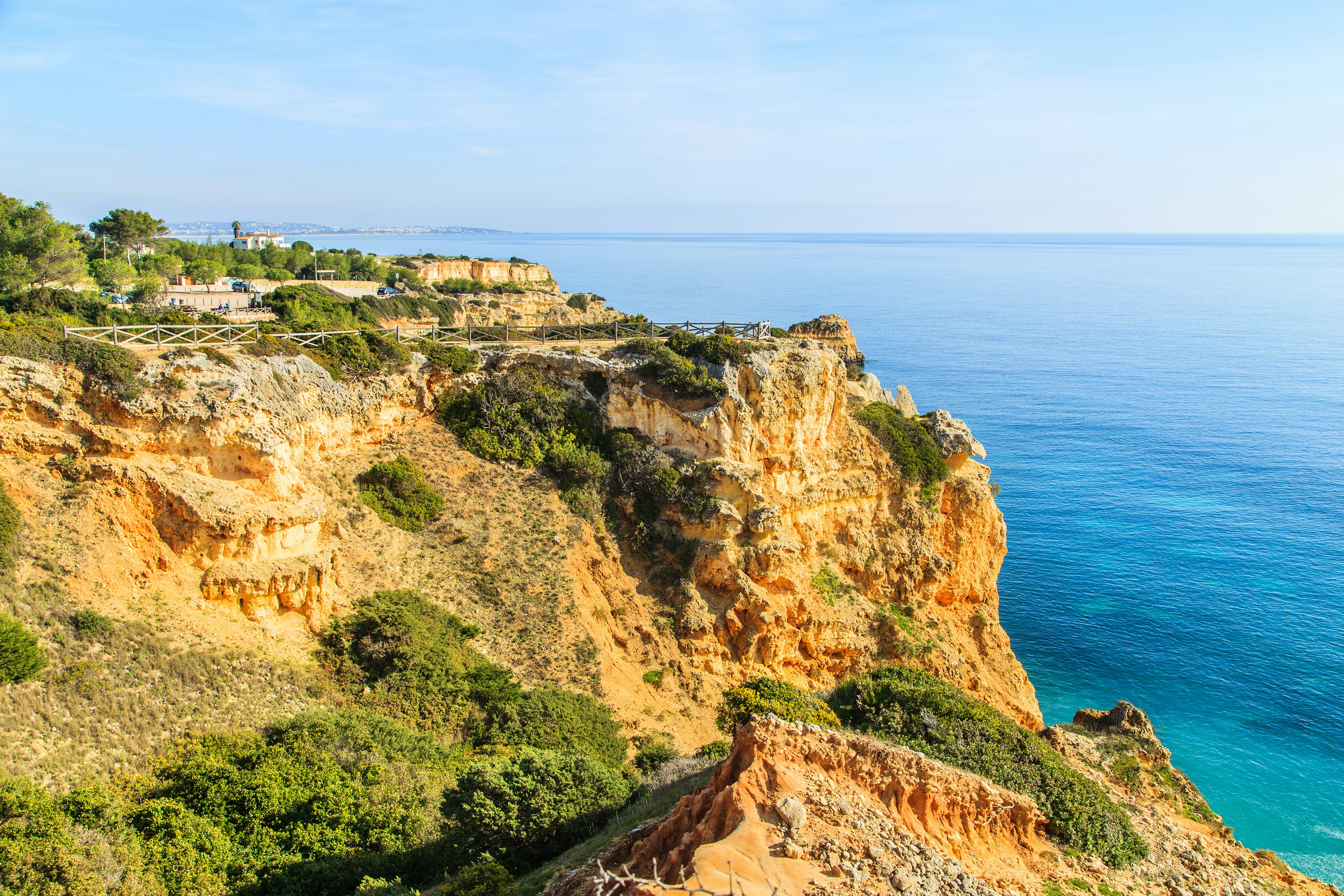 An ochre-colored cliff sits above the Atlantic at the Parque Natural da Ria Formosa