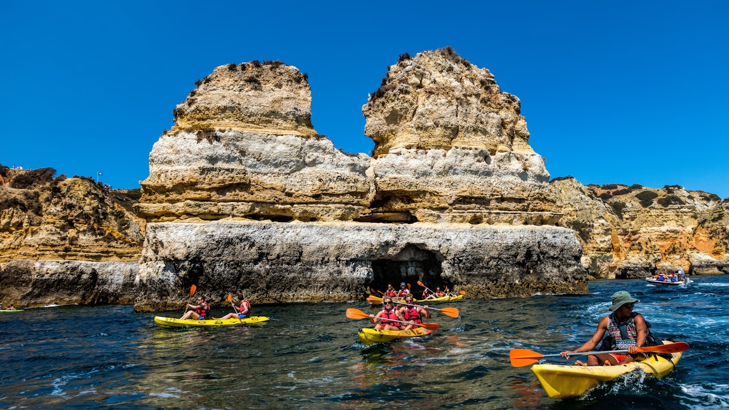 Lagos, Portugal, August 18, 2017: Kayak boats exploring the Ponta da Piedade rock formations near Lagos, Portugal