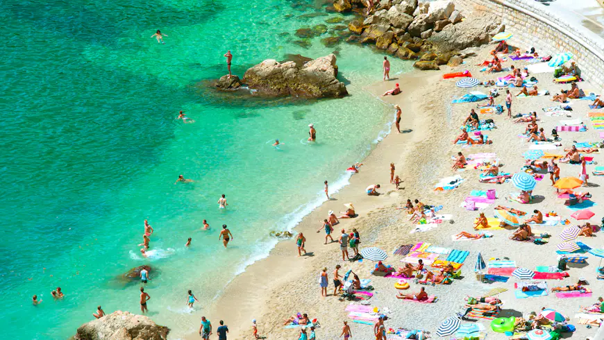 Sunseekers line the pebble beach in Nice