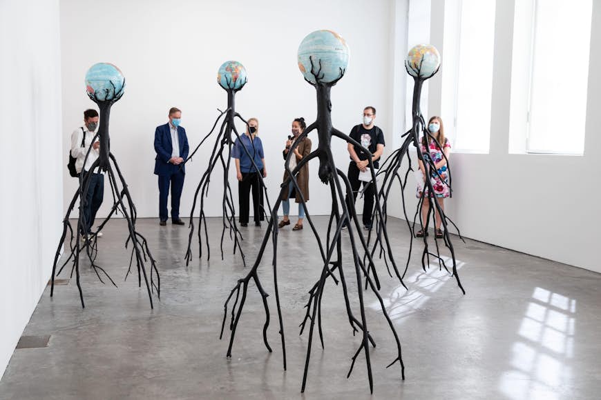 An art exhibition with strange branch-like structures holding up globes