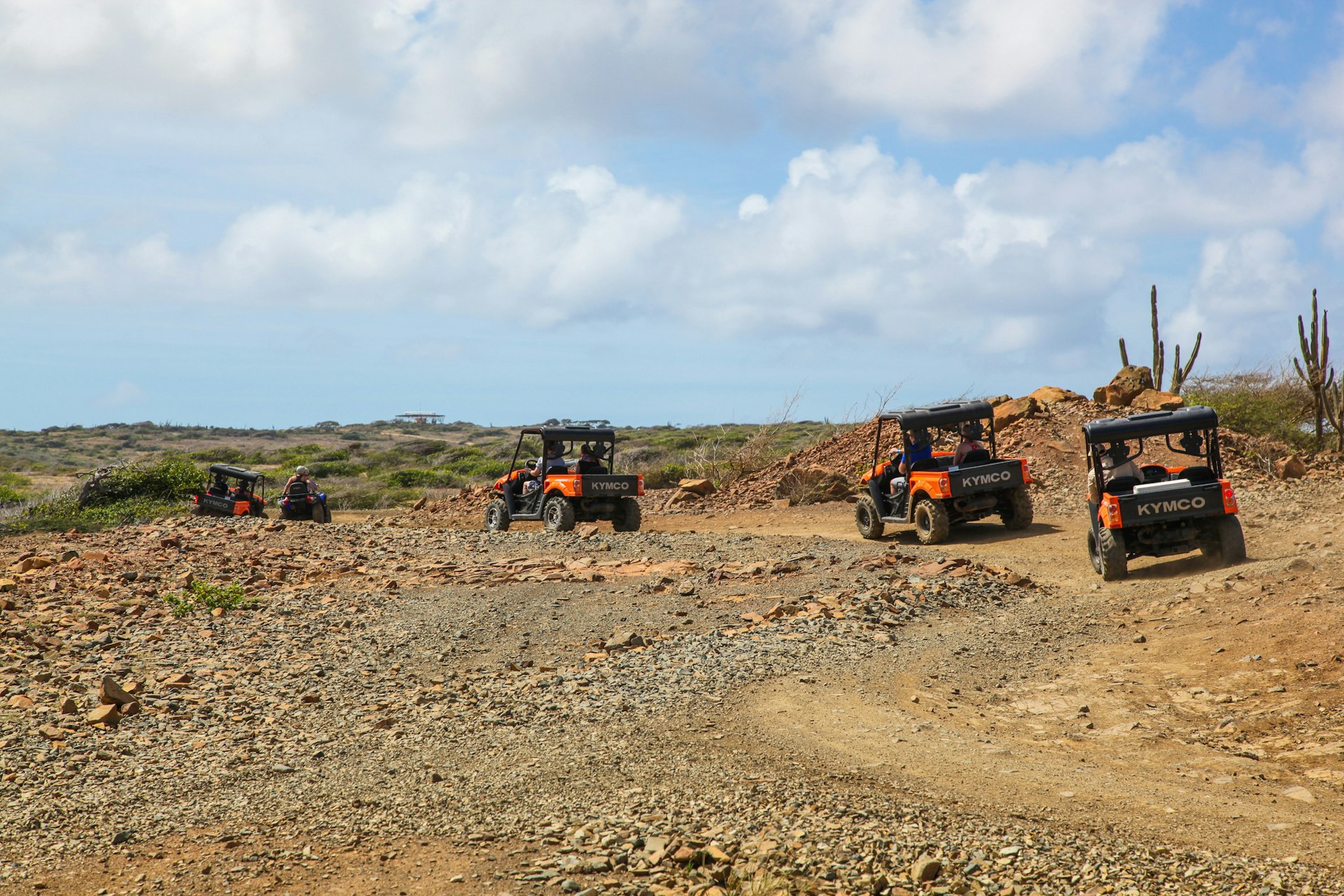 Tourists on a tour of Arikok National Park in Aruba, following dirt paths in four-wheel-drive buggies