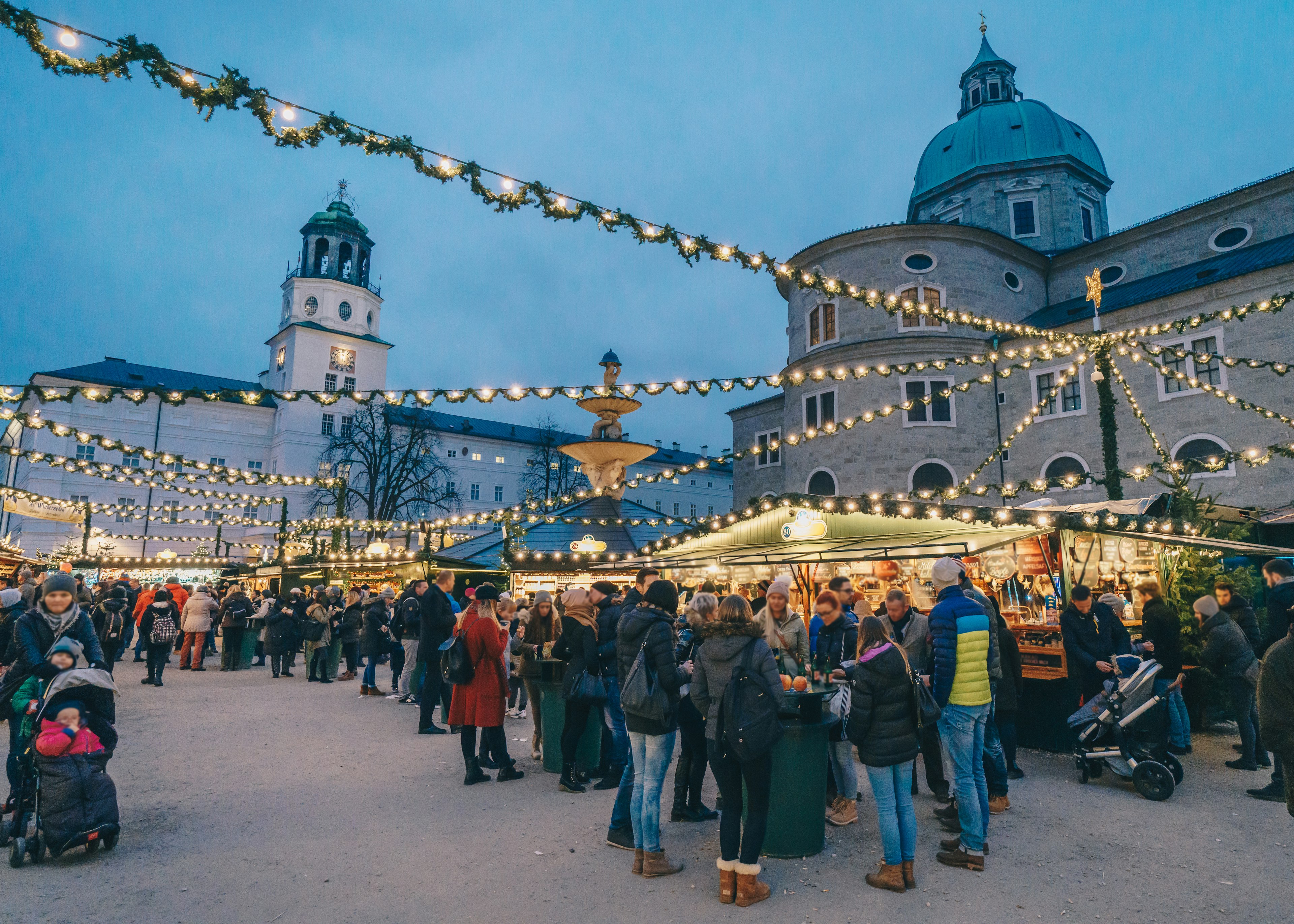 Warmly dressed people sipping mulled wine at a Salszburg Christmas Market
