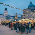 Warmly dressed people sipping mulled wine at a Salszburg Christmas Market