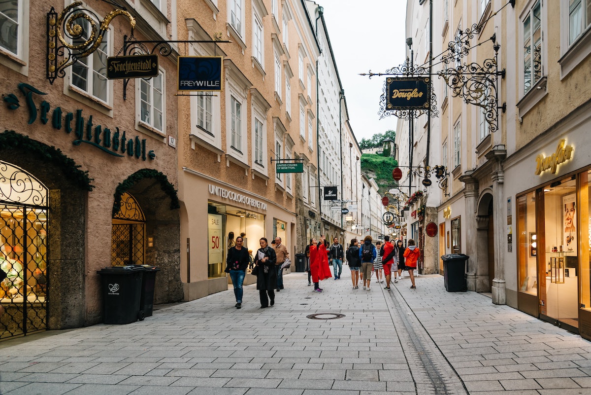 Pedestrians walk by shops on the car-free Getreidegasse in the historic old town of Salzburg, Austria