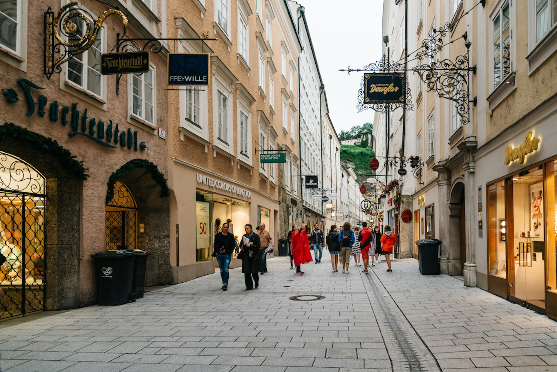 Pedestrians walk by shops on the car-free Getreidegasse in the historic old town of Salzburg, Austria