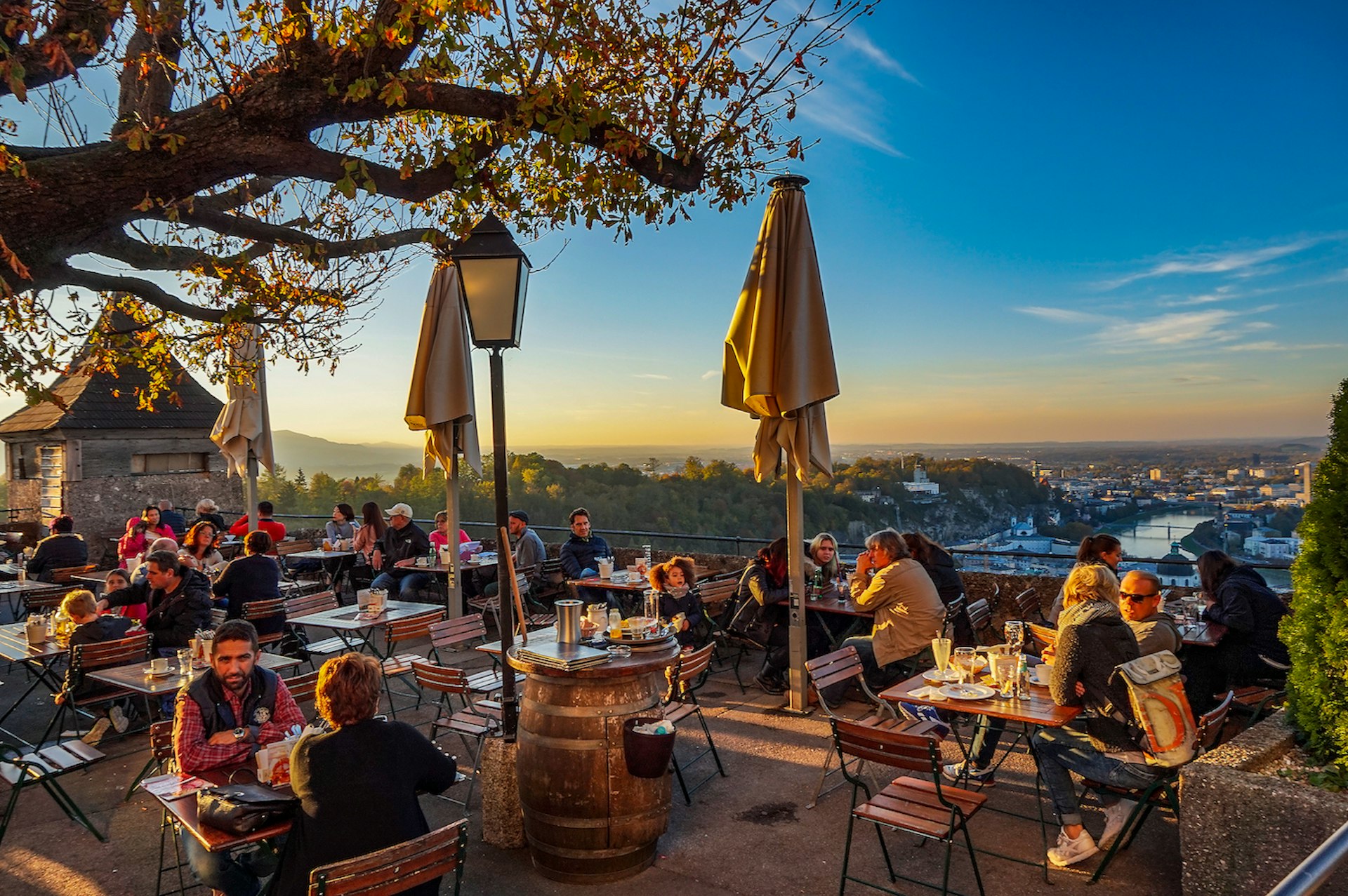 People at tables at an outdoor terrace at the cafe at Hohensalzburg Fortress, Salzburg, Salzburgerland, Austria, Europe