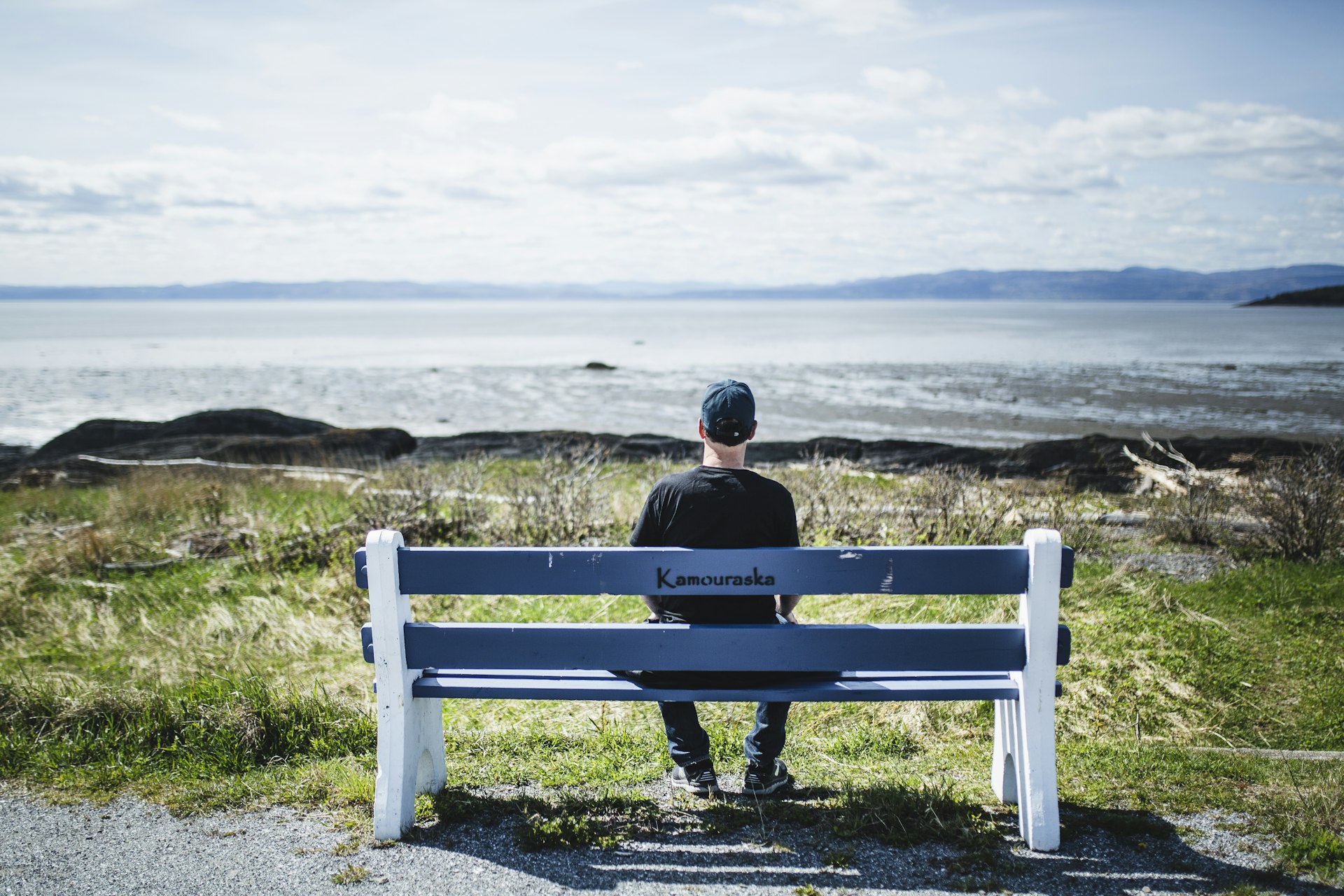 A man sitting watching the river in Kamouraska, Quebec