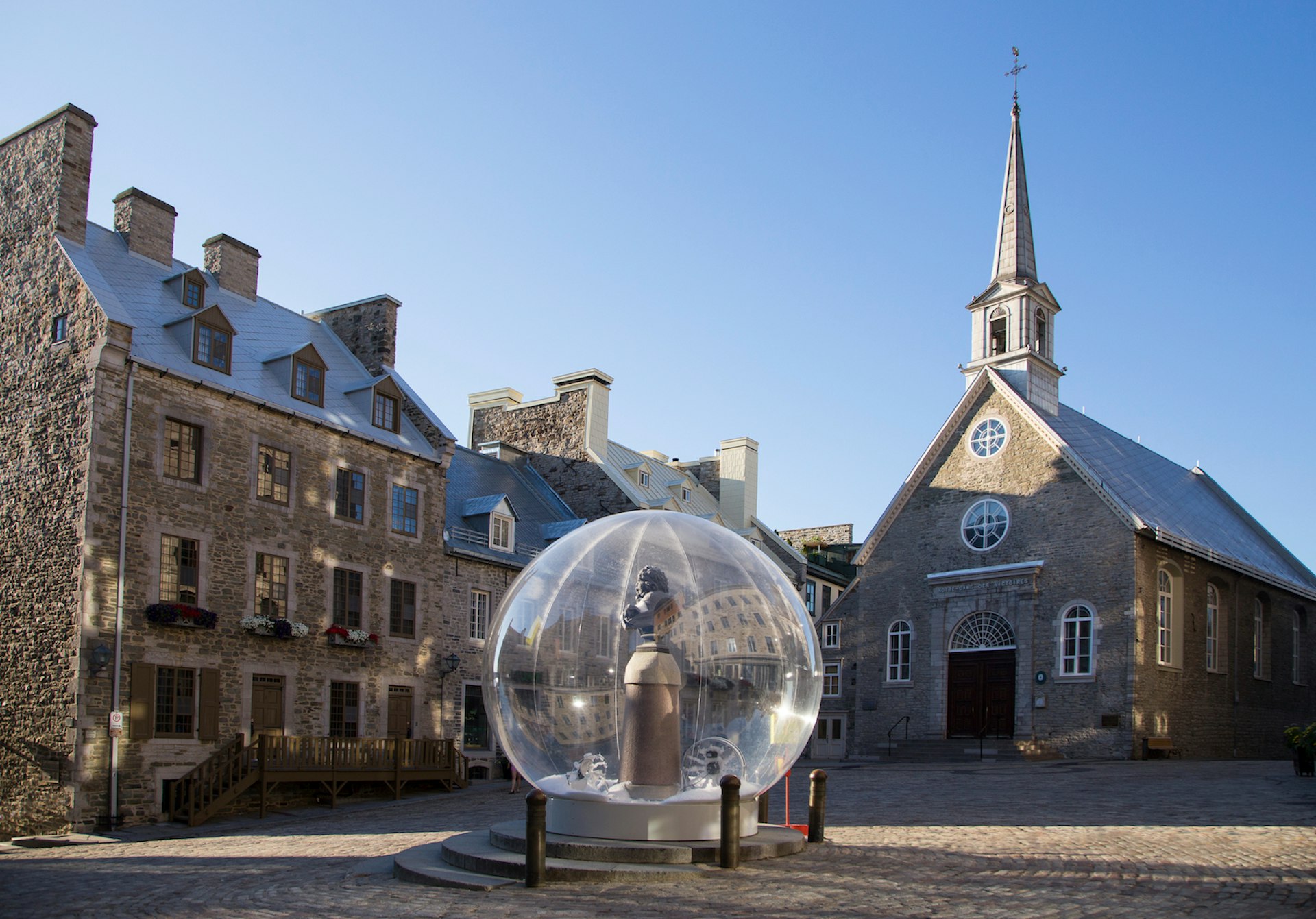 A Louis XIV bust encased in a snow bubble for the “Eternal Snow” installation during the Passages Insolites art show in Place Royale, Old Québec, Québec City, Québec, Canada