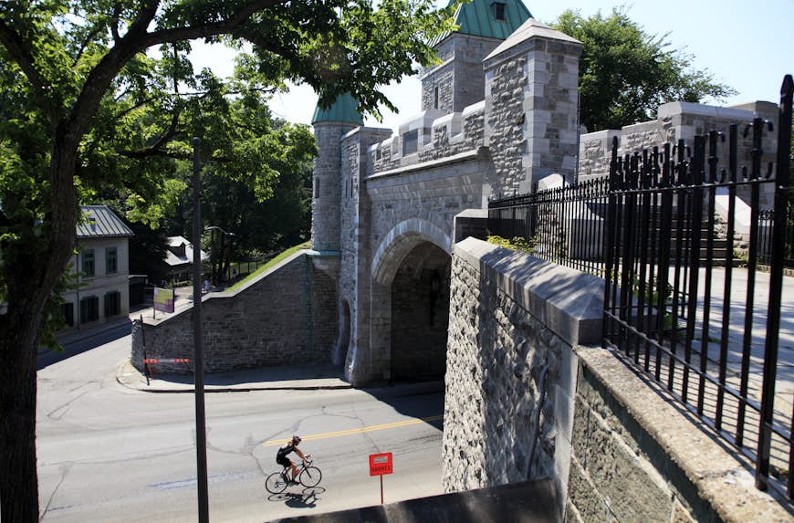 A lone cyclist about to pass through the Porte Saint-Louis in the Old Town, Québec City, Québec, Canada