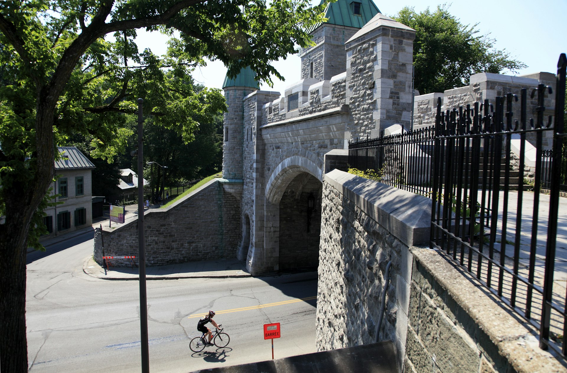 A lone cyclist about to pass through the Porte Saint-Louis in the Old Town, Québec City, Québec, Canada