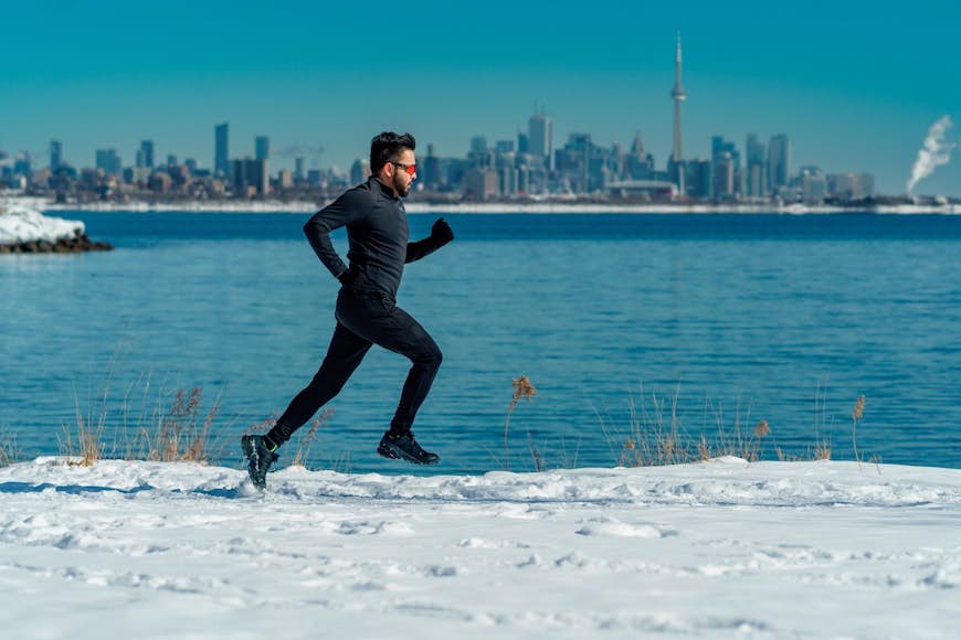 A runner on a snowy path on Lake Ontario in Toronto, Ontario, Canada