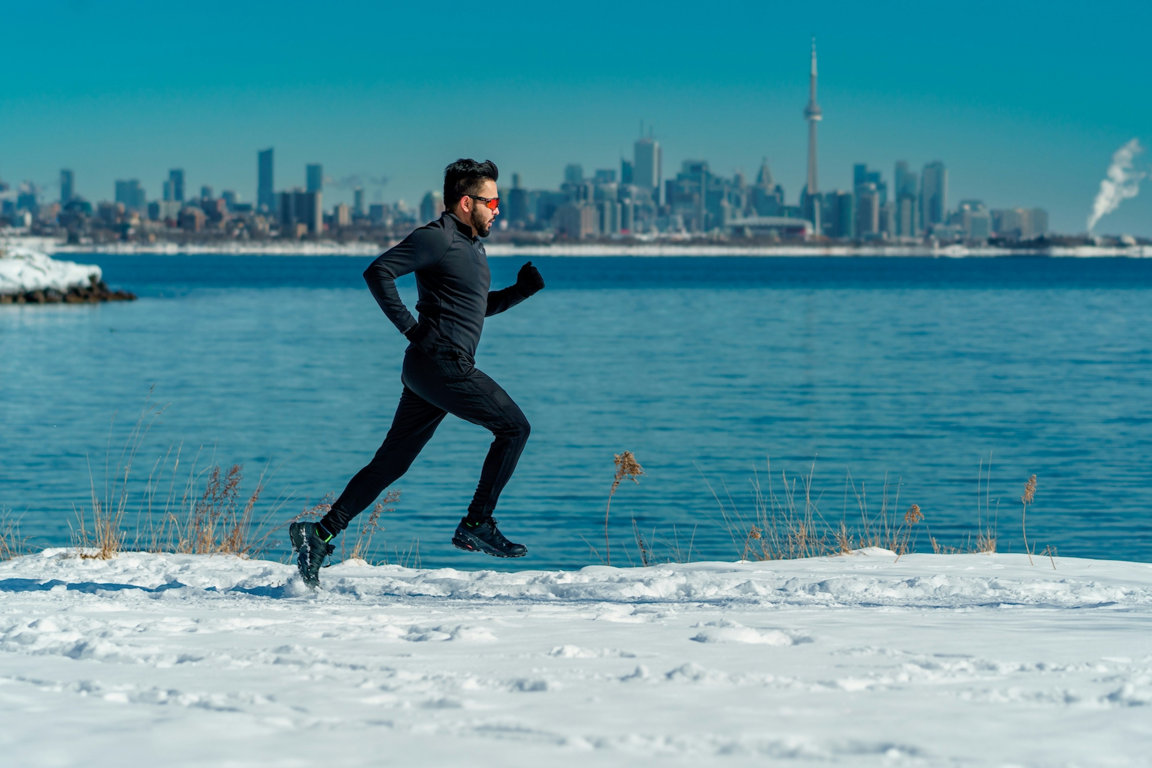 A runner on a snowy path on Lake Ontario in Toronto, Ontario, Canada