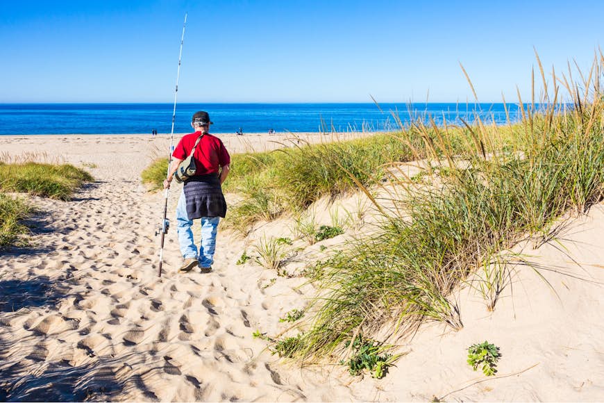 This fisherman heads to the water at the Cape Cod Natural Seashore to fish. 