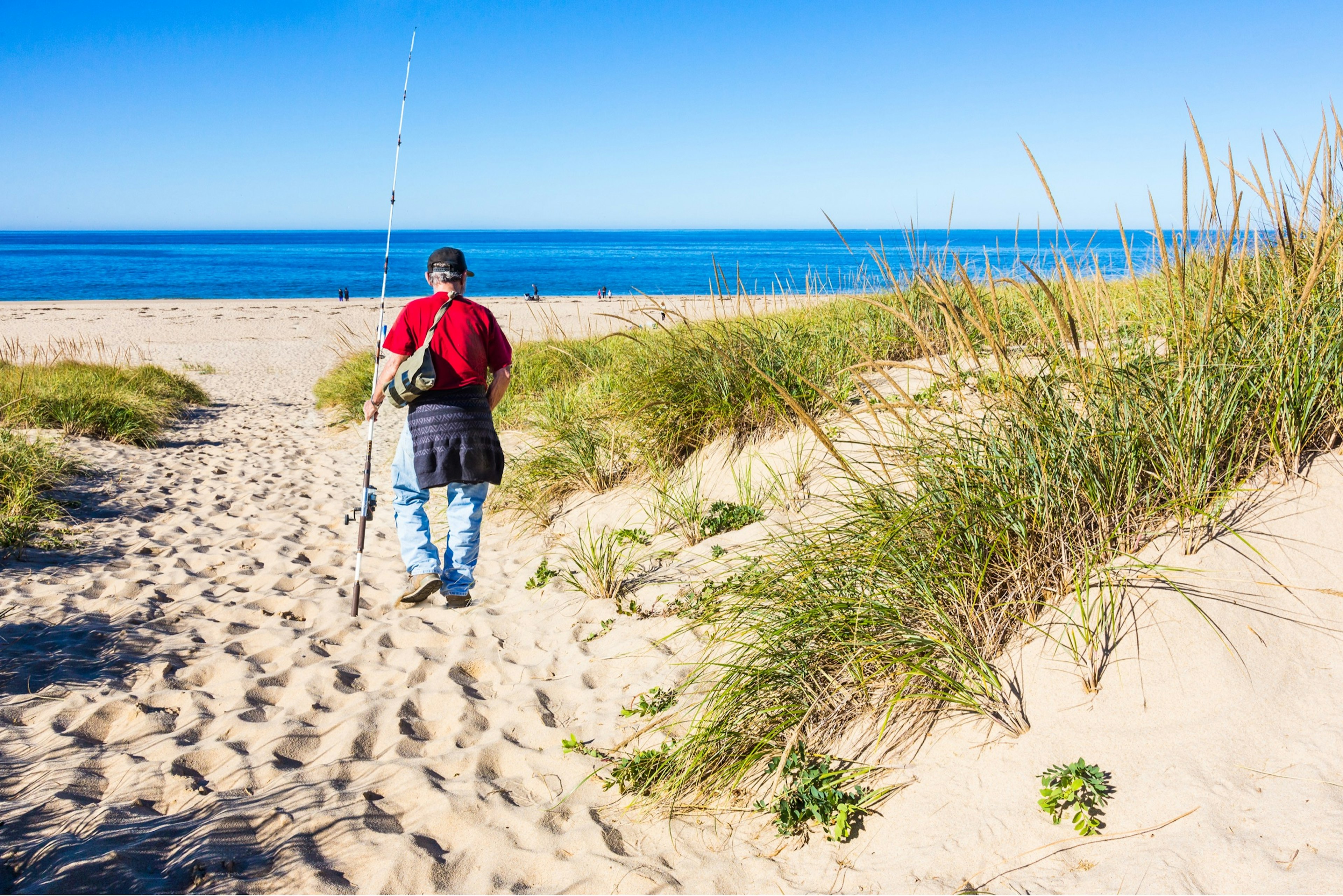 This fisherman heads to the water at the Cape Cod Natural Seashore to fish.