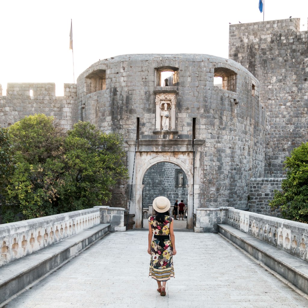 Woman Walking Towards Pile Gate Entrance to Old Town Dubrovnik - stock photo