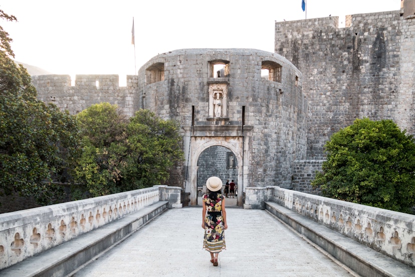 Woman Walking Towards Pile Gate Entrance to Old Town Dubrovnik - stock photo