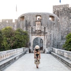 Woman Walking Towards Pile Gate Entrance to Old Town Dubrovnik - stock photo