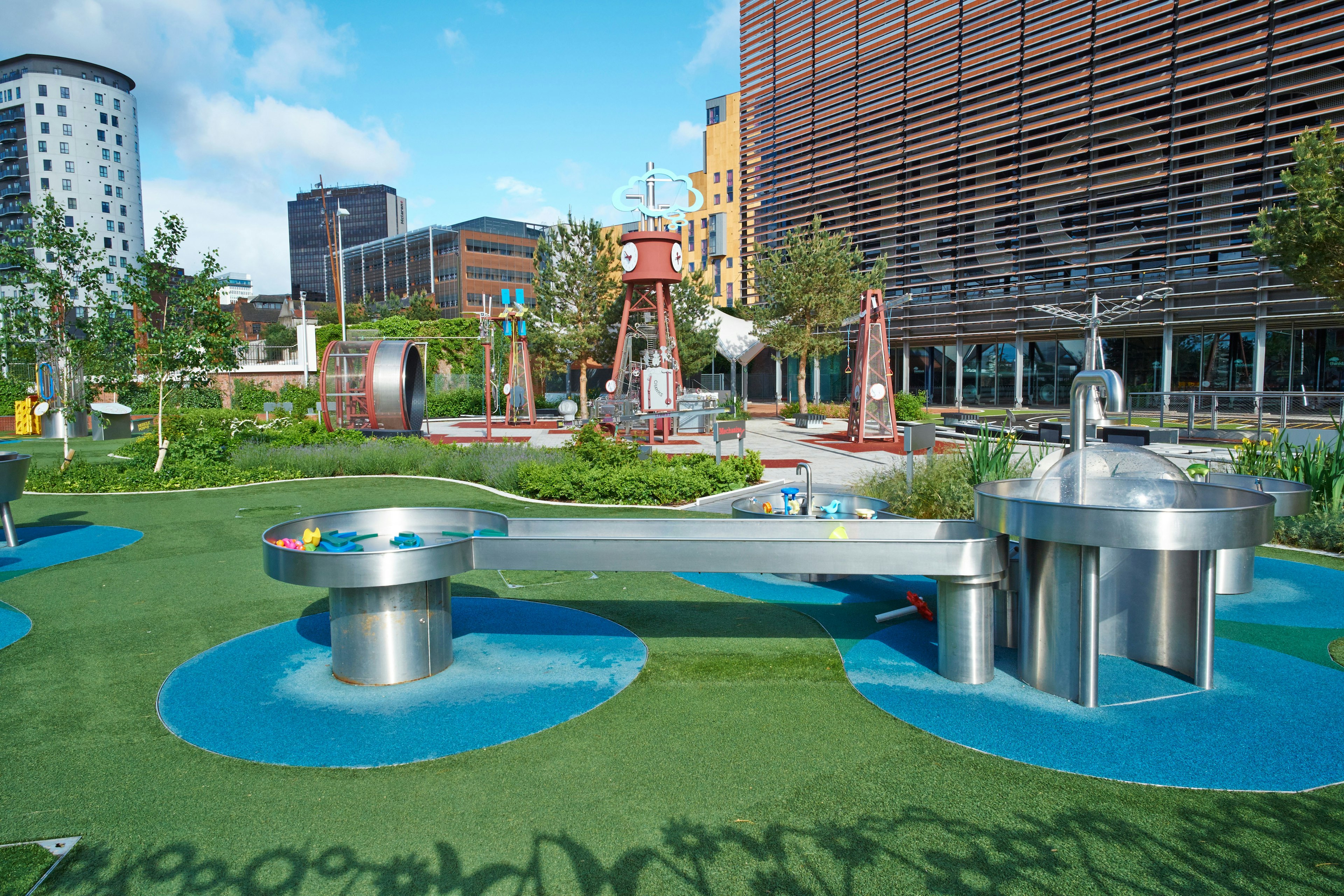 An outside play area for children, with troughs for water play and tunnels to climb through