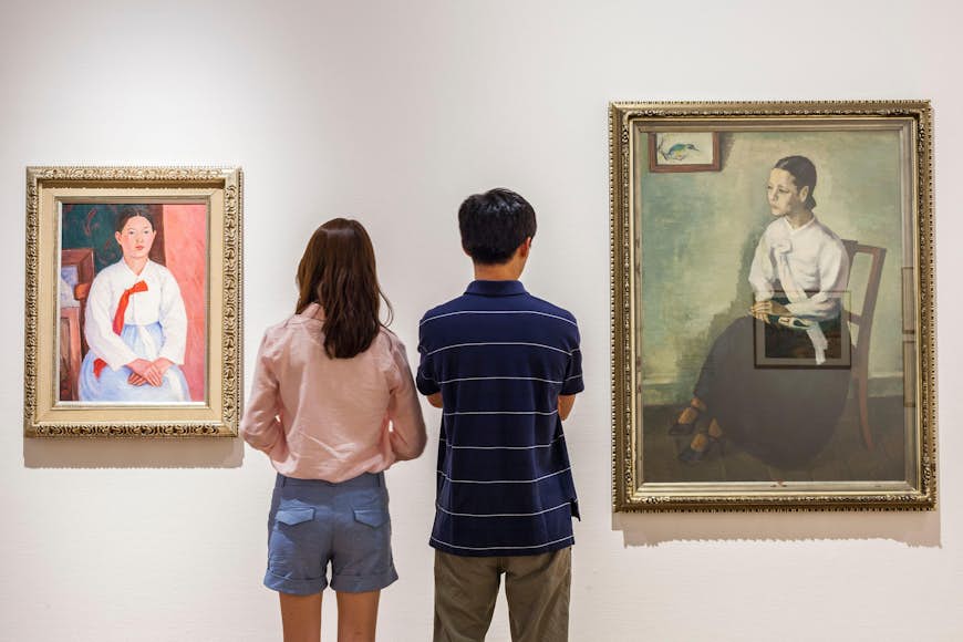 Two visitors look at paintings at the National Museum of Modern and Contemporary Art in Seoul, South Korea