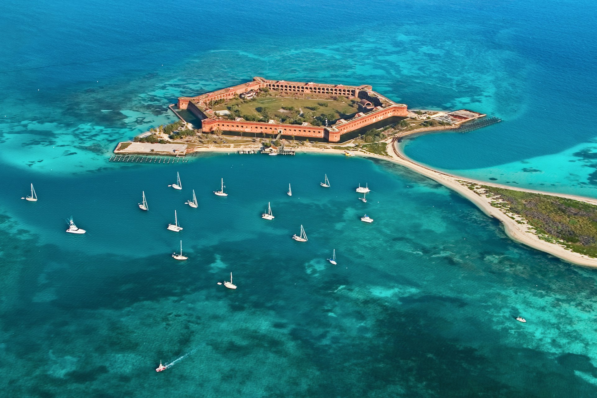 An aerial shot of sailboats moored in the bright blue waters surrounding Fort Jefferson, Garden Key, Dry Tortugas National Park, Florida, USA