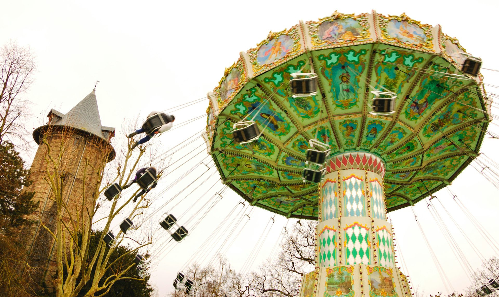 A chain carousel in motion with swings flying out as the carousel spins