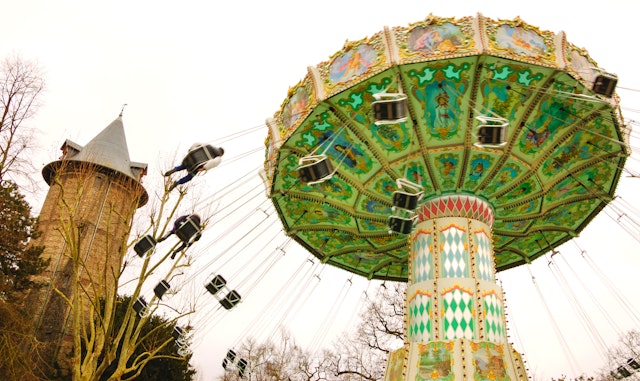 A chain carousel in motion with swings flying out as the carousel spins