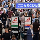 Travellers queue at Geneva Airport on June 15, 2022 after Swiss airspace was closed after a computer glitch with the air traffic control system grounded flights at the country's main airport. - Swiss airspace reopened on June 15, 2022 morning after a computer glitch grounded flights across the Alpine nation for several hours, officials said. (Photo by Fabrice COFFRINI / AFP) (Photo by FABRICE COFFRINI/AFP via Getty Images)