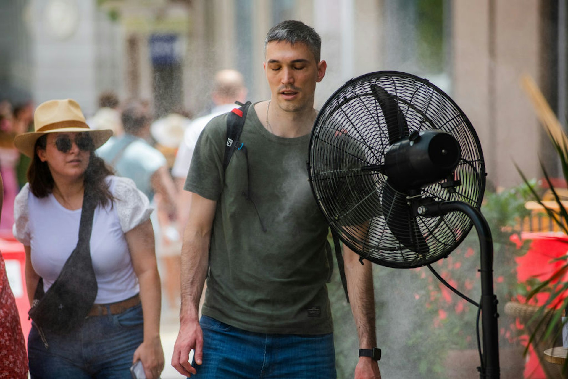 A pedestrian cools himself in front of an electric fan in Madrid