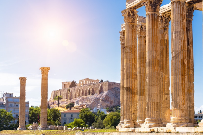 Zeus temple overlooking Acropolis, Athens, Greece. These are famous landmarks of Athens. Sunny view of Ancient Greek ruins, great columns of classical building in Athens city center.