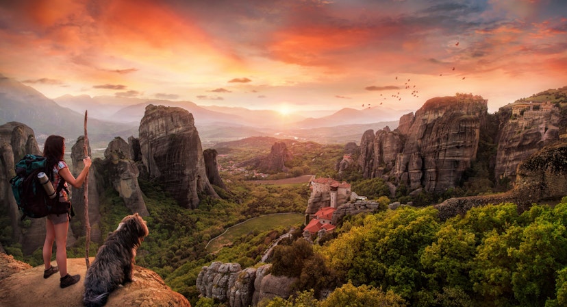 A backpacker and a dog in a breathtaking landscape at Meteora, Greece