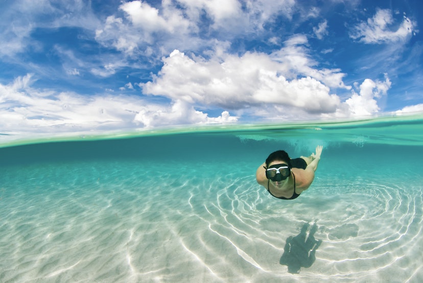Woman snorkelling in the Caribbean waters of Roatan island