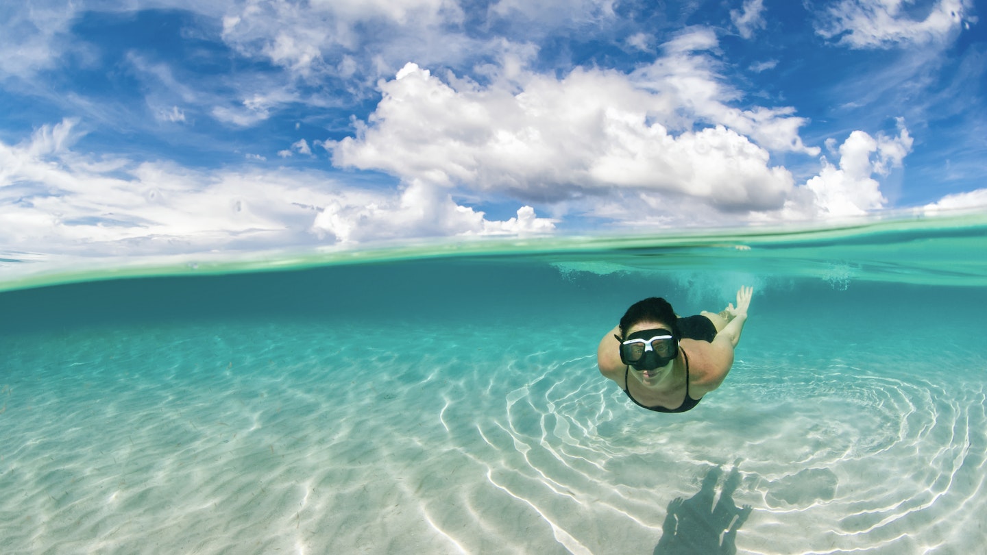 Woman snorkelling in the Caribbean waters of Roatan island