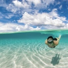 Woman snorkelling in the Caribbean waters of Roatan island