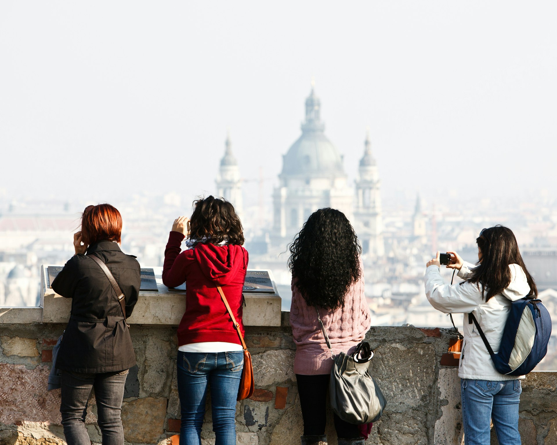 Four female tourists taking photos of Budapest with the basilica in the distance